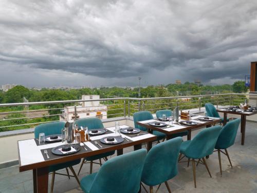 a restaurant with tables and chairs on a roof at Hotel Rudura Palace in Udaipur