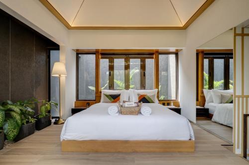 パンガンダランにあるAmanara Villa Pangandaranの大きな白いベッドと窓のある寝室