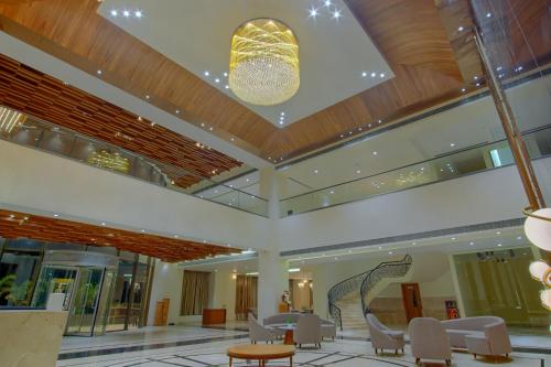 a lobby with a table and chairs and a chandelier at DNT Plaza in Morbi