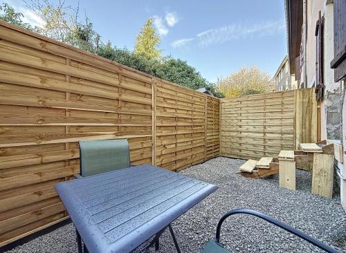 a wooden privacy fence with a bench and a chair at Appartement-Terrasse in Montbéliard