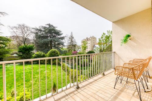 a balcony with a table and chairs and a view of a park at Le Palais des Secrets - 10 minutes de Paris - Balcon in Vanves
