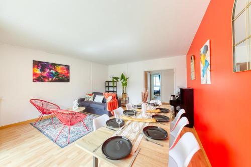 a living room with a wooden table and an orange wall at Le Palais des Secrets - 10 minutes de Paris - Balcon in Vanves