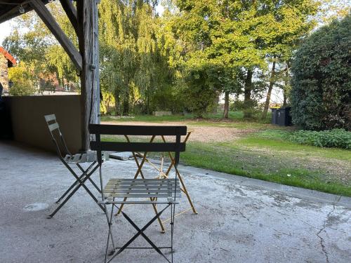 a bench and a chair in a park at Gîte de L'Oliviade - Campagne & Confort in Billancelles