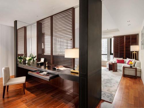 a living room with a desk and a couch at Fairmont Wuhan in Wuhan