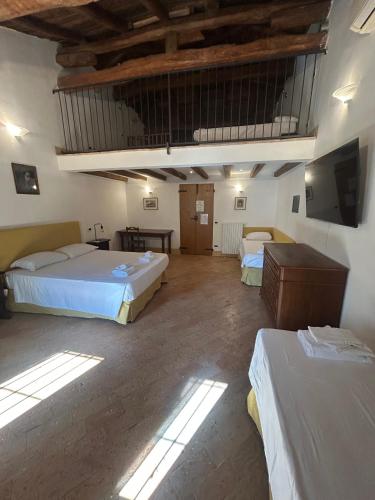 a large room with two beds and a television at BolognaRoomscom - Ca' Palazzo in Sasso Marconi