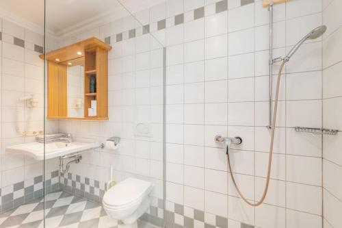 a bathroom with a shower and a toilet and a sink at Reisslerhof Hotel & Apartments - by myNests in Gröbming