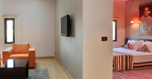 a bedroom with a bed and a tv and a chair at Design Hotel Mr President in Belgrade
