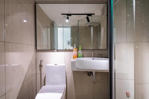 a bathroom with a sink and a toilet and a mirror at The Rixx Saigon Central - Next to Ben Thanh Market in Ho Chi Minh City