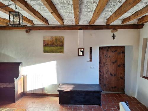 a room with a bench and a cross on the wall at Can Pedragos in Sales del Llierca