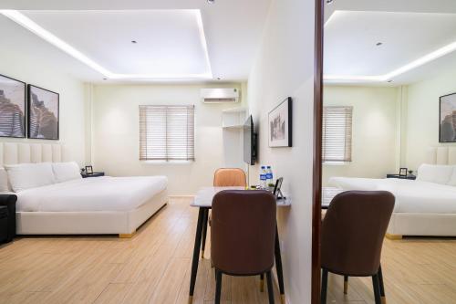 a room with two beds and a table and chairs at The Rixx Saigon Central - Next to Ben Thanh Market in Ho Chi Minh City
