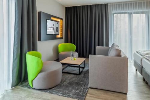 a living room with two chairs and a couch at elaya hotel kevelaer in Kevelaer