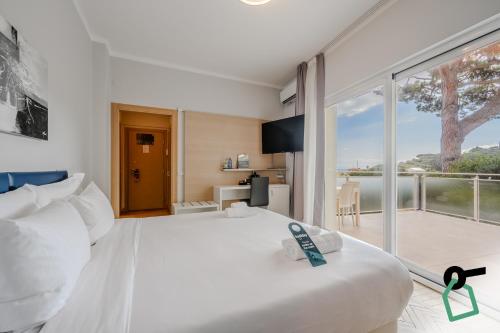 a bedroom with a white bed and a large window at Hotiday Santa Margherita Porto in Santa Margherita Ligure