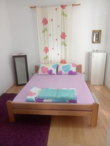 Un dormitorio con una cama morada con una manta morada. en Palamar, en Kuršumlija