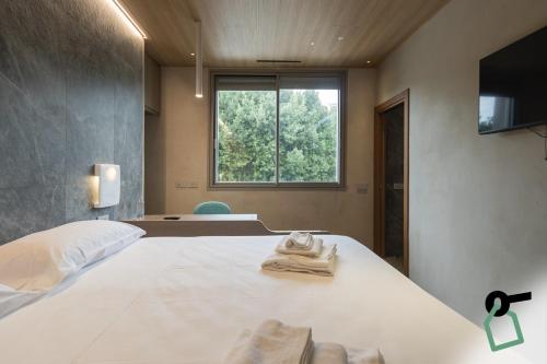 a bedroom with a large white bed with a window at Hotiday Lerici Trebiano in Lerici