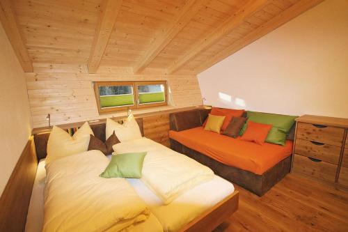 a room with two beds and a couch in a room at Alpin Chalet Kleinarl in Kleinarl