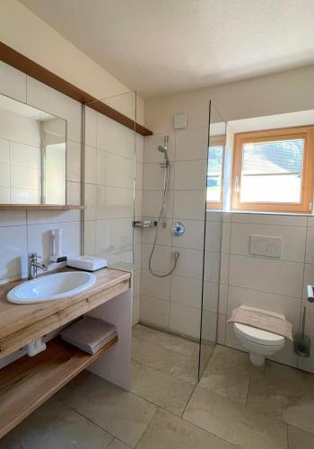 a bathroom with a shower and a sink and a toilet at Alpin Chalet Kleinarl in Kleinarl
