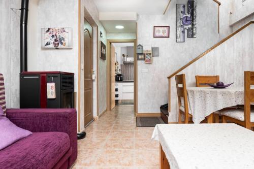 a living room with a purple couch and a table at Chalet adosado Anayet in Sabiñánigo