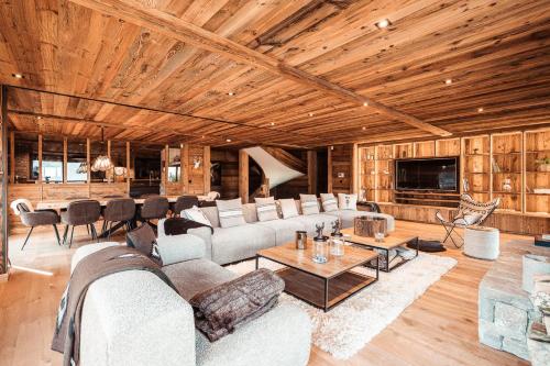 a living room with a couch and a table at Belmont - New & ecological chalet in the heart of Combloux in Combloux