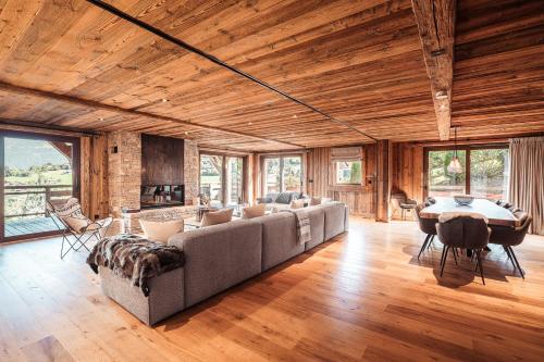a large living room with a couch and a table at Belmont - New & ecological chalet in the heart of Combloux in Combloux