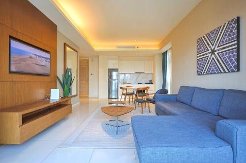 a living room with a blue couch and a table at Tribeca Residence Bukit Bintang in Kuala Lumpur