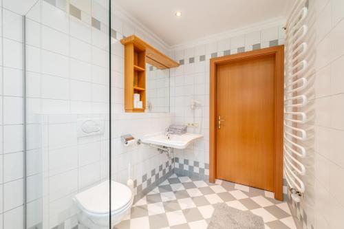 a bathroom with a toilet and a sink at Reisslerhof Hotel & Apartments - by myNests in Gröbming