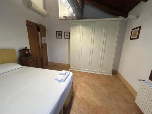 a bedroom with a white bed and a large cabinet at BolognaRoomscom - Ca' Palazzo in Sasso Marconi