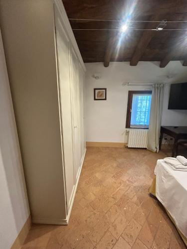 an empty room with a bed and a window at BolognaRoomscom - Ca' Palazzo in Sasso Marconi
