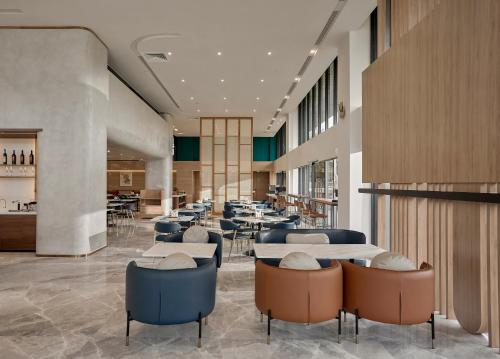 Un restaurante con mesas y sillas y una cafetería. en TC Hotel Binh Duong New City, en Ga Phú Trung