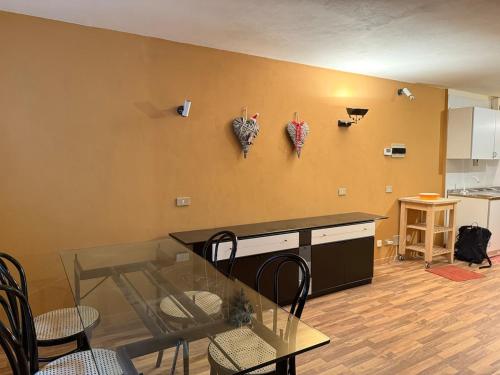 a dining room with a glass table and a kitchen at Ski & Relax Nido Alpino a Cervinia Cielo Alto in Breuil-Cervinia