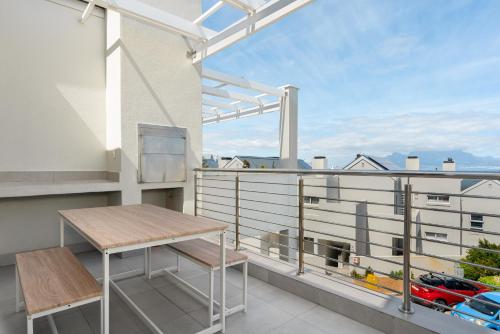 Un balcón con una mesa y vista a un edificio. en Bona View Estate 30, en Cape Town