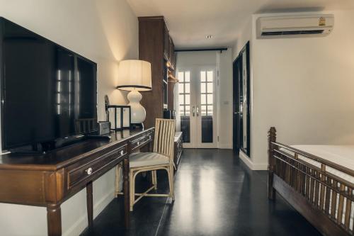 a living room with a television on a desk at Buri Siri Boutique Hotel in Chiang Mai