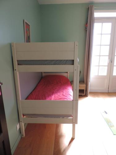 a bunk bed in a room with a red bed at L'Opporak in Lindry