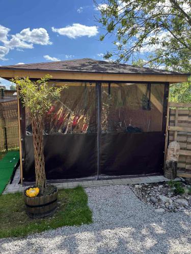 a screened in gazebo with a tree at Tiny house Podbieľanská Archa in Podbiel