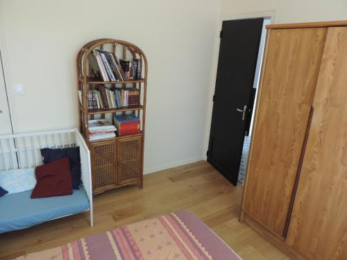a room with a book shelf and a bed and a door at L'Opporak in Lindry