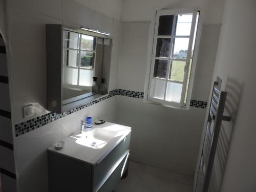 a white bathroom with a sink and a window at L'Opporak in Lindry