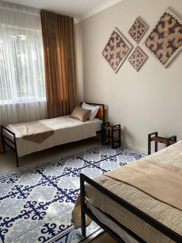 a bedroom with two beds and a blue rug at Ala-Tor in Pokrovka