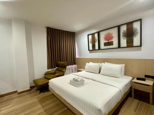 a hotel room with a bed and a chair at Sakura Sky Residence in Bangkok