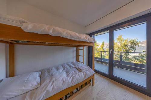 Un dormitorio con una litera y un balcón. en Cosy appartement, Nid d'Aigle J0, 2 chambres, en Nendaz
