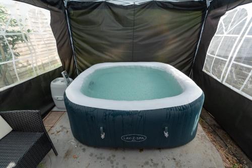 a large tub in a tent with a toilet at Open Mind Property - 9 Guests & Free Parking in Portsmouth