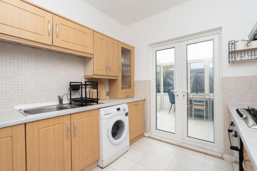 a kitchen with a sink and a washing machine at Open Mind Property - 9 Guests & Free Parking in Portsmouth