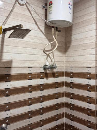 a bathroom with a shower with wooden walls and a light at Hotel Yash in Prayagraj