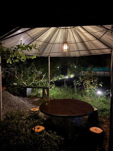 a table under an umbrella in a garden at night at The Munroe Vibes Inn in Munroe Island