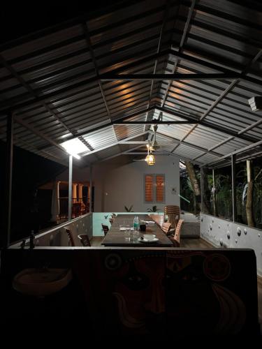 a dining room with a long table and chairs at The Munroe Vibes Inn in Munroe Island
