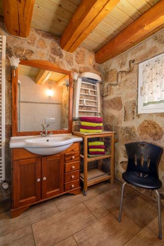 a bathroom with a sink and a chair at Märchenhafte Ferienhäuser in Zaulsdorf