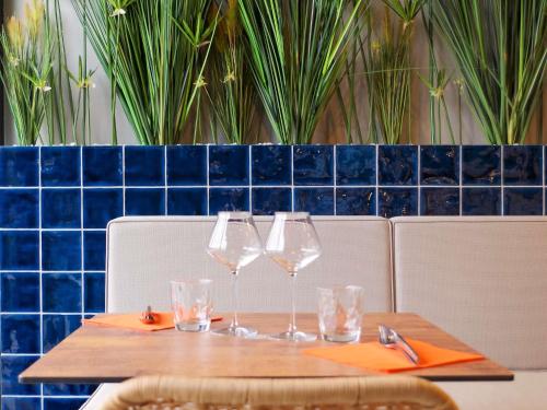 a wooden table with wine glasses on top of it at Ibis Lunel Petite Camargue in Lunel