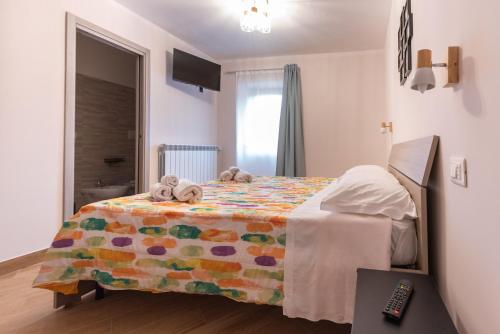 a bedroom with a bed with a colorful blanket at Le Coste in Villetta Barrea