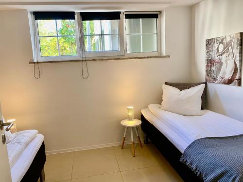 two twin beds in a room with two windows at Møllehusets lejligheder i Ikast tæt ved Herning, Silkeborg og Århus in Ikast