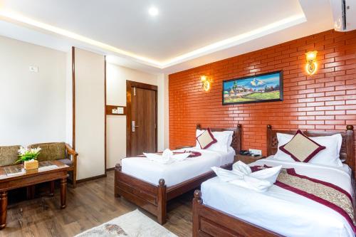 a bedroom with two beds and a brick wall at Royal Boutique Hotel in Kathmandu