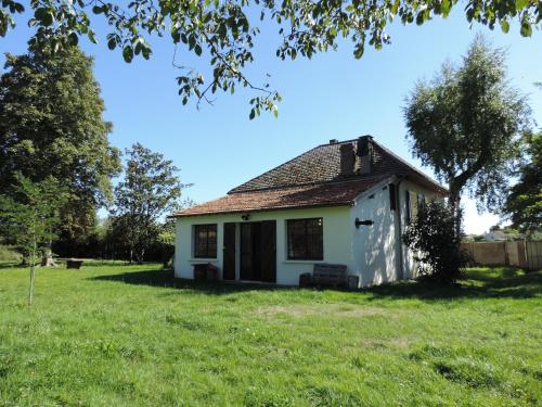 an old white house in a field of grass at L'Opporak in Lindry