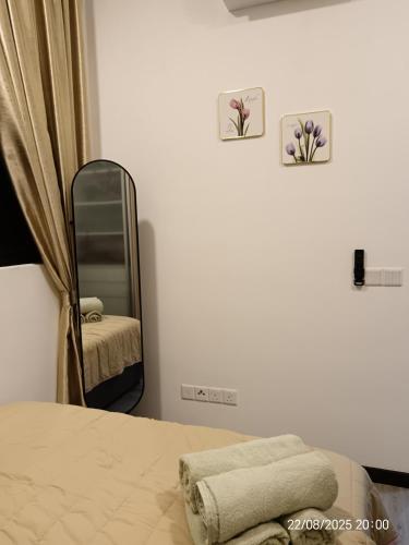 a bedroom with a mirror and a bed with towels at Executive Antara Homestay Putrajaya near PICC, UITM Dengkil in Putrajaya